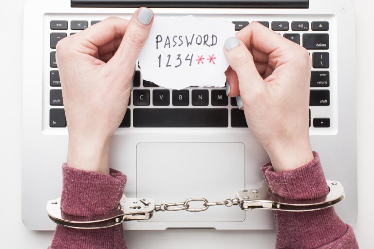 top-view-hands-with-handcuffs-holding-laptop-password